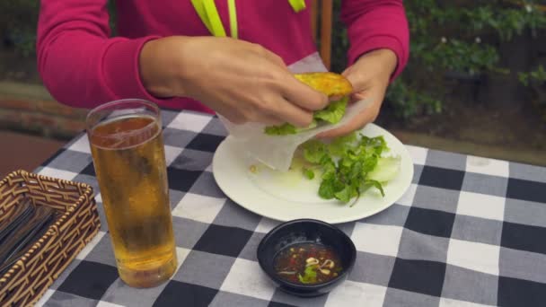 Een vrouw maakt een vegetarisch broodje van rijstpapier, Groenen en omelet — Stockvideo