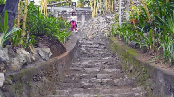 La mujer desciende por las escaleras de piedra en el templo budista — Vídeos de Stock