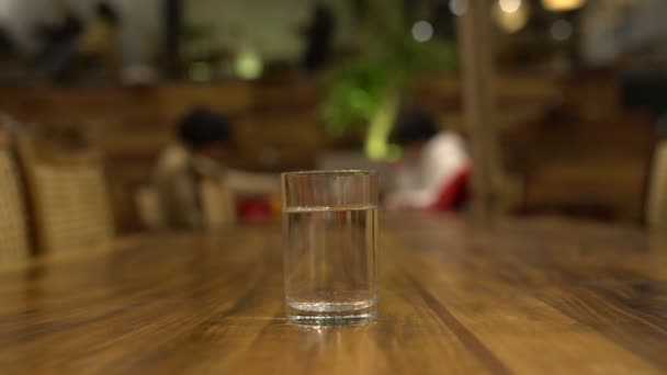 On the table in the restaurant is a glass of water — Stock Video