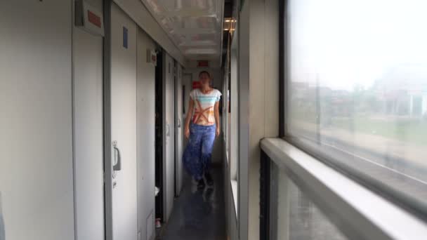 Una donna cammina vicino al vagone ferroviario ed entra nello scompartimento — Video Stock