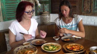 Restoran deniz ürünleri ve tavuk şiş yiyen kadınlar