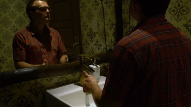 Мужчина моет руки в раковине и вытирается полотенцем. — стоковое видео