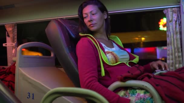 在睡眠公共汽车的妇女降低了座位的后面, 关闭窗口与窗帘和戴上面具 — 图库视频影像