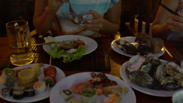 Жінка в ресторані їсть запечені мідії за допомогою пробки — стокове відео