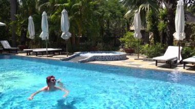 Kadın havuzda yüzüyor