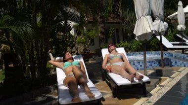 Mayolu bir güneşlenme üzerinde güneşlenme kadınlar. Bir kokteyl içme kadın