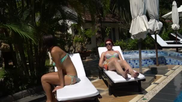 Une femme prend un bain de soleil sur une chaise longue avec un cocktail. Vient une girland tombe sur la chaise longue — Video