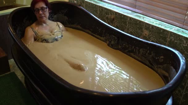 Женщина расслабляется в грязевой ванне — стоковое видео