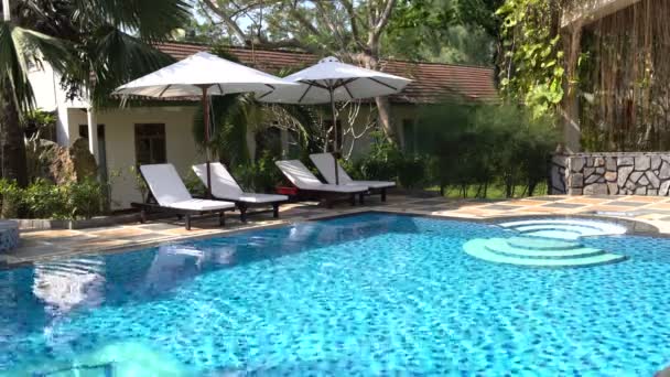 Venkovní bazén. Nedaleké stojan sluneční lůžka se slunečníky — Stock video