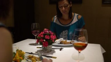 Restoranda, bir masada oturan kadın konuşmak, yemek yeme, bokalomi kırmızı şarap ve içki ile tıklatması