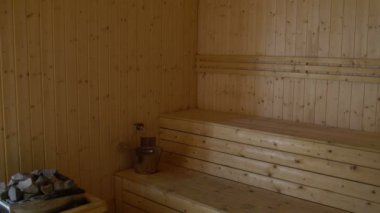 Bir kadın bir sauna yürüyor ve gölgelik üzerinde oturur