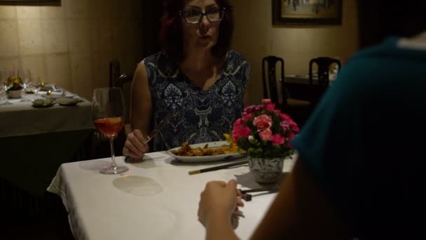 W restauracji, kobieta siedzi przy stole, jedzenia, rozmowy, brzęk szkła i pić czerwone wino — Wideo stockowe