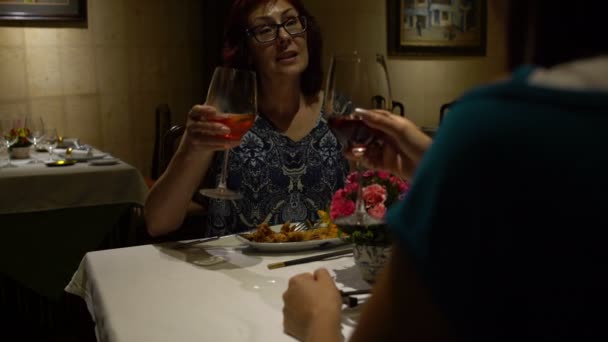 Kobiet w restauracji sidijat w tabeli. Kobieta rodzi szkła, chokaetsja i picie czerwonego wina — Wideo stockowe