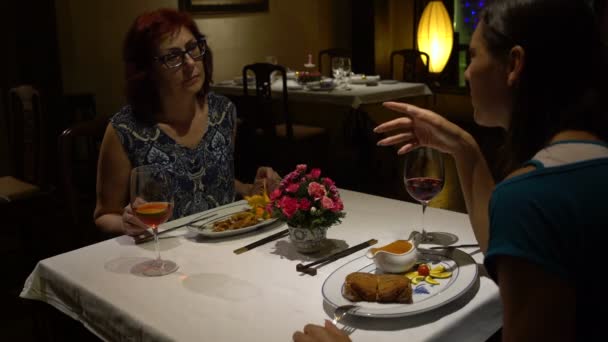 Las mujeres hablan sentadas en una mesa en el restaurante — Vídeos de Stock