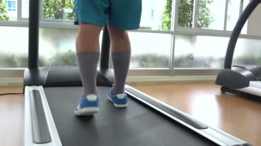 Spor salonunda treadmill üzerinde bir adam