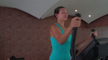 Kadın bir eliptik egzersiz üzerinde spor salonunda yapıldı.