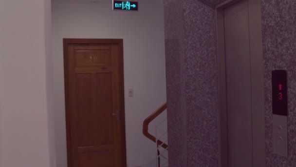 女性がエレベーターを終了し 彼の部屋に行く — ストック動画