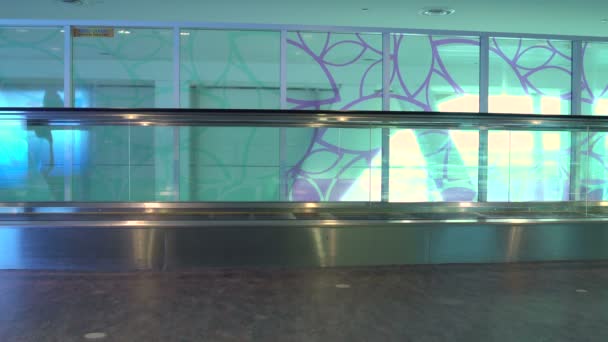 Μια γυναίκα χρησιμοποιεί ένα κυλιόμενο διάδρομο σε ένα τερματικό σταθμό του αεροδρομίου — Αρχείο Βίντεο