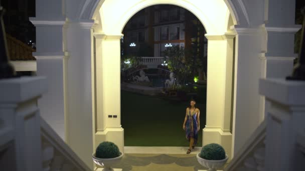 晚上的城市。一个女人穿过拱门爬上楼梯 — 图库视频影像