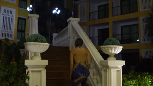 Una donna sale le scale nella città di notte — Video Stock