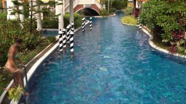 Havuzu ve yüzer merdivenlerden bir mayo içinde kadın