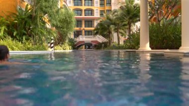 Kız havuzda köprüye yüzüyor.