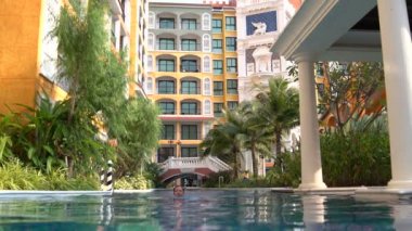 Kadın sütunlar ve köprüden ile açık yüzme havuzunda yüzüyor