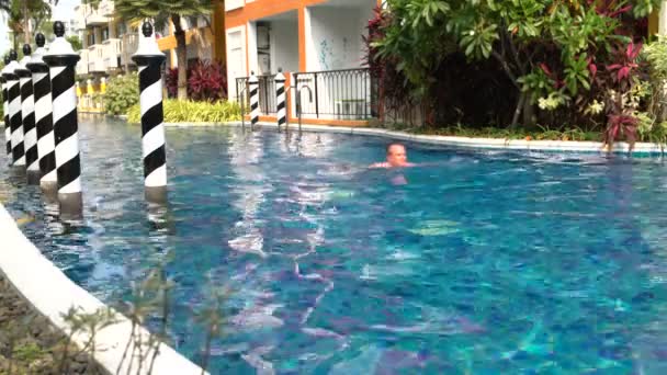 Мужчина плавает в бассейне в отеле — стоковое видео