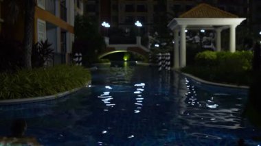 Kadın havuzda akşam yüzüyor.