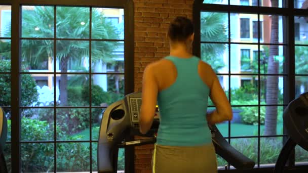 Chica en una cinta de correr en el gimnasio — Vídeos de Stock