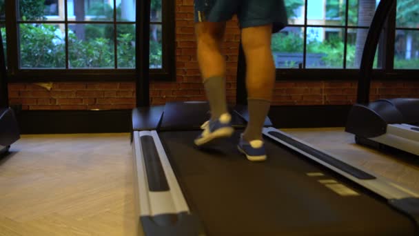 Jambes des hommes sur un tapis roulant à la salle de gym — Video