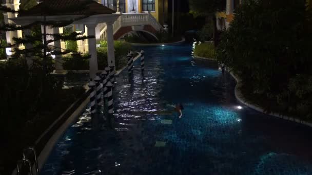 Woman swims backstroke in an evening outdoor pool — Stock Video