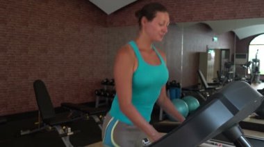 bir koşu bandı üzerinde çalışan kadın