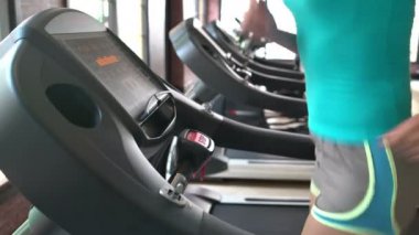 Kızı spor salonunda koşu bandı üzerinde çalışan