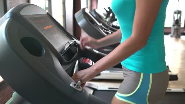 Fille sur un tapis roulant à la salle de gym — Video