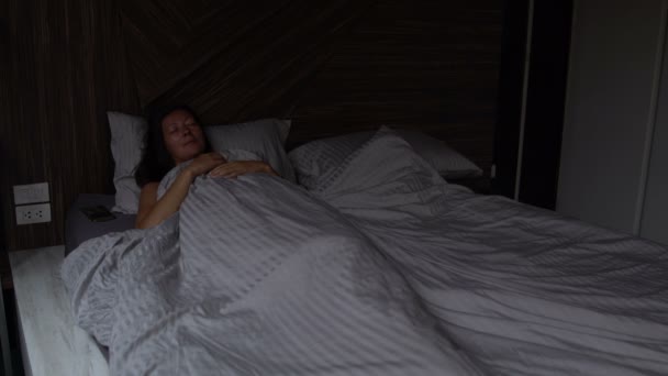 女性がベッドで眠っています。アラームがオフになる、少女が目を覚ます、点灯 — ストック動画