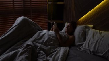 Kız yatakta smatrfon kullanır