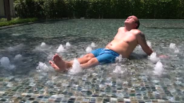 Homem de calções ao sol perto da piscina — Vídeo de Stock