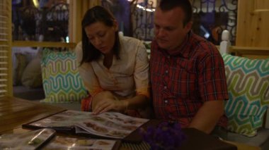 Bir restoranda bir kadınla bir adam bak menü