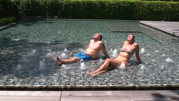 Marito con moglie abbronzatura a bordo piscina — Video Stock