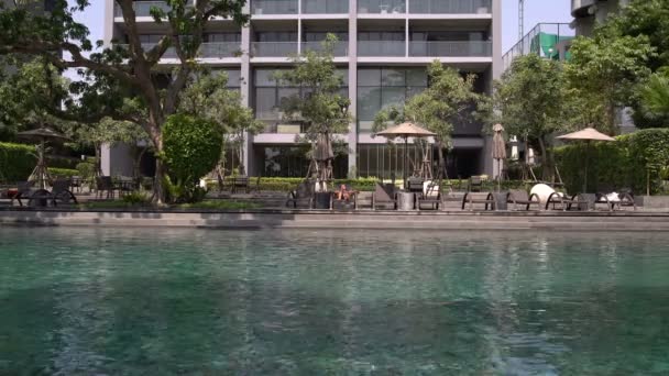Woman in a bathing suit sunning on a sun lounger by the pool — Stock Video