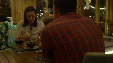 Bir çift bir restoranda yemek, söz ve kırmızı şarap içme