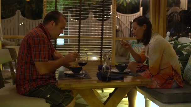 Restauracja, mężczyzny i kobiety siedzącej przy stole, jedzenia i mówienia — Wideo stockowe