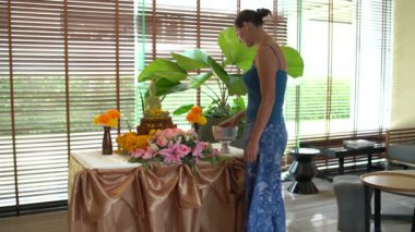 Songkran. Tay Yeni yıl. Bir kadın su Buda heykeli yasemin yaprakları ile dökülen