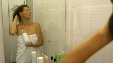 Kadın saç saç kurutma makinesi banyoda ayna önünde kurur