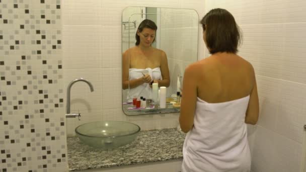 Vrouw vochtinbrengende crème toe te passen op gezicht — Stockvideo