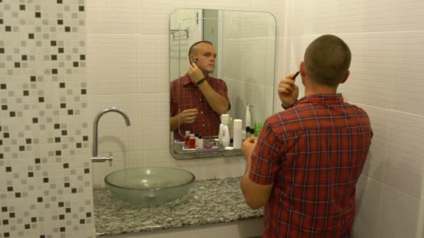 Man shaves in front of a mirror — Stock Video