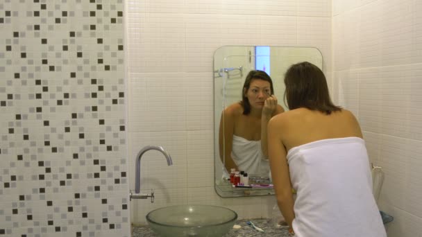 Femme peint les yeux devant un miroir — Video