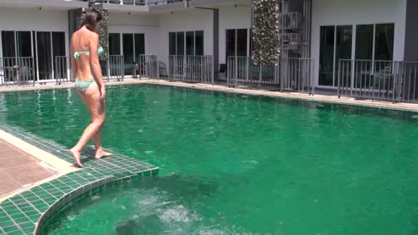 Una mujer entra en la piscina y nada — Vídeos de Stock