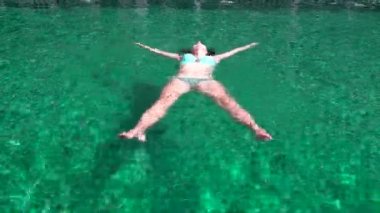 Havuzda bir mayo içinde kadın yatıyor